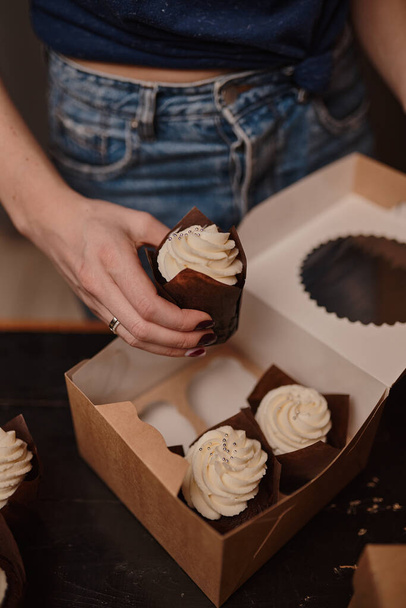 Packaging of delicious homemade muffins with whipped cream in a cardboard box. - Fotoğraf, Görsel