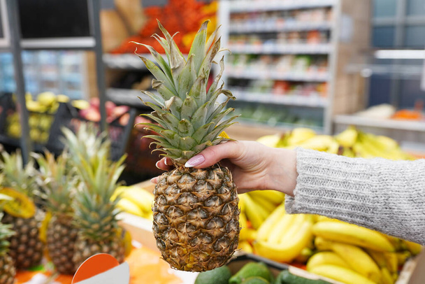 Közelkép, szupermarket, piac, élelmiszerbolt nők kézzel választja ananász, az egészséges élelmiszer és életmód fogalma - Fotó, kép