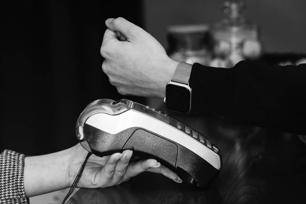 Mann bezahlt mit Smartwatch-Anwendung im Bekleidungsgeschäft, Nahaufnahme, Blickwinkel - Foto, Bild