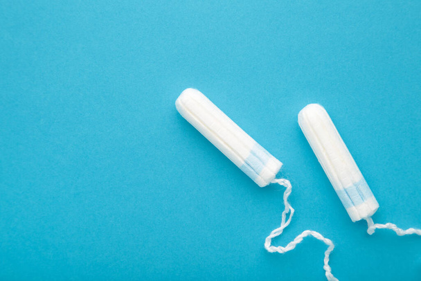 Menstrual tampons on a blue background. Cotton tampon for women. Top view - Fotó, kép