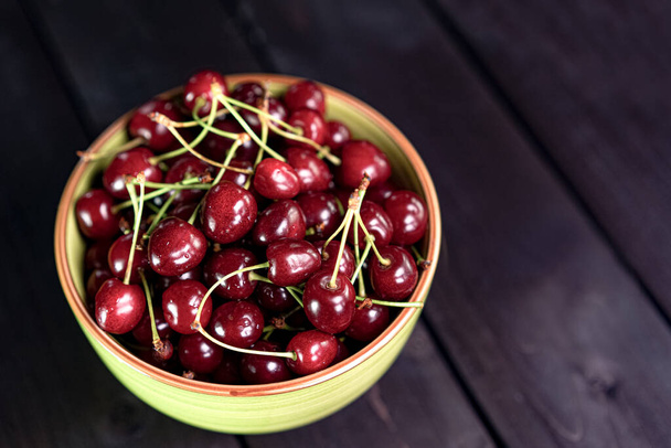 Cherry in a cup on a wooden background - Fotó, kép