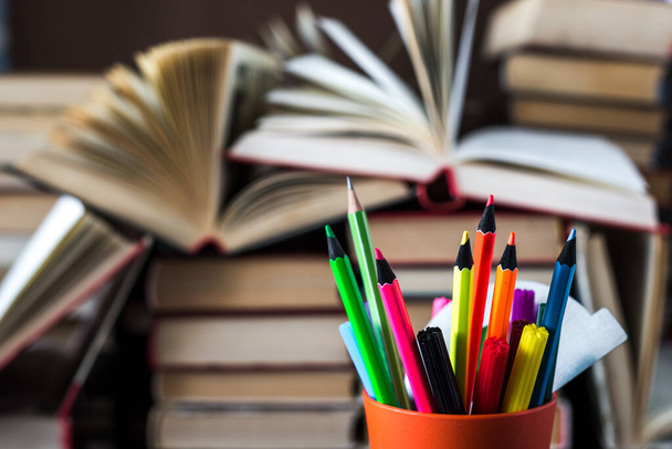 Egy halom könyv és ceruza egy asztalon az általános iskolában. Egy halom színes könyv. Oktatási háttér. Az üzleti oktatás koncepciója. A szöveg másolási helye. - Fotó, kép