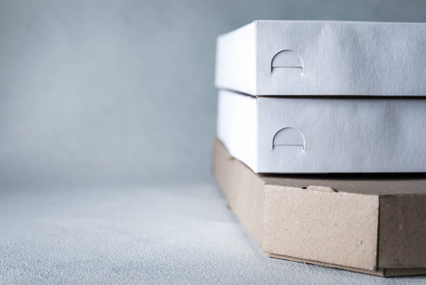 Thuisbezorging, online bestellen. Witte doos in voorraad klaar voor uw bericht of logo. Levering van producten en producten tijdens quarantaine - Foto, afbeelding