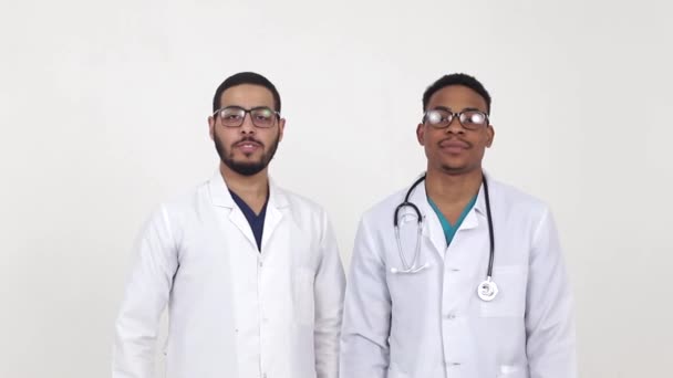 Deux collègues dans le domaine médical de la race mixte montrent un pouce vers le haut. - Séquence, vidéo