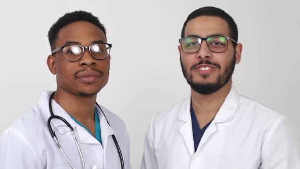 The two best smart professional smiling doctors work in white coats, - Footage, Video