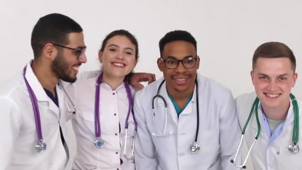 Ryhmä lääketieteen opiskelijoita hymyilee sairaalassa, lääkärit sekoitettu rotu - Materiaali, video