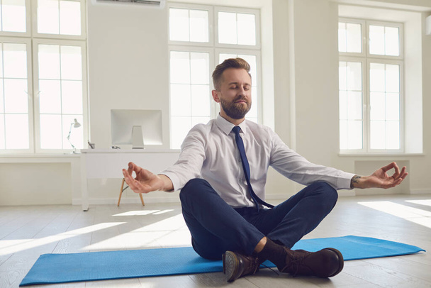 Businessman meditates at the workplace in the office. - Foto, imagen