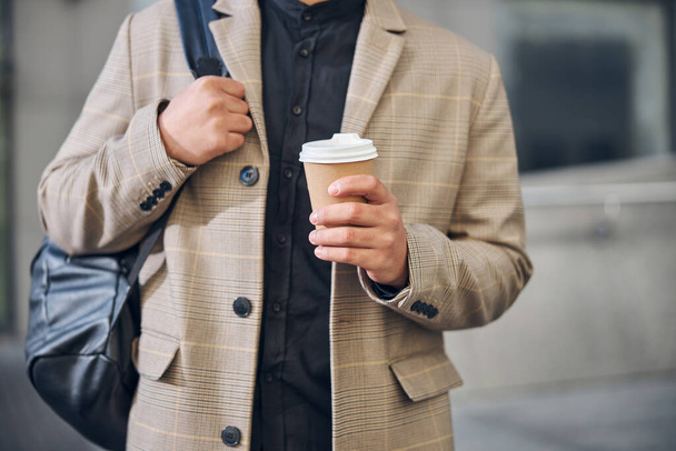 Stylish young man holding cup of coffee - Fotó, kép