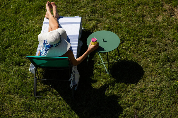 Arka bahçede güneşlenen kadın manzarası yaz eğlencesi - Fotoğraf, Görsel
