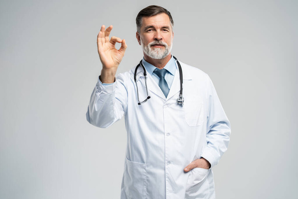 Happy smiling doctor with thumbs up gesture, isolated on white background. - 写真・画像