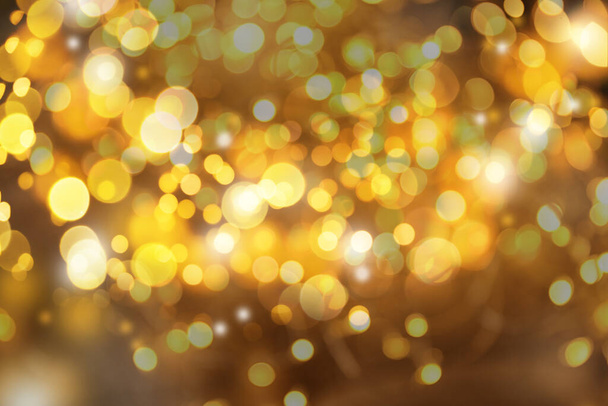 Blurred view of gold lights as abstract background, bokeh effect - Photo, image