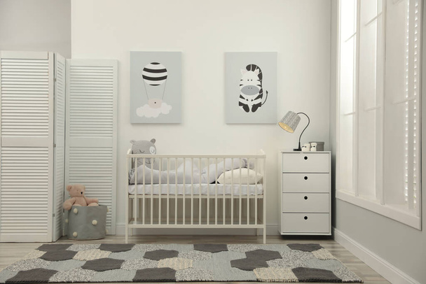 Stylish baby room interior with crib and chest of drawers - 写真・画像