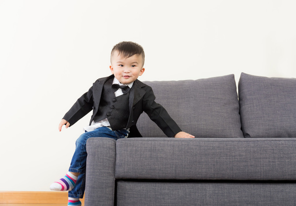 kicsi fiú ülő kanapé - Fotó, kép