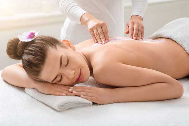 Beautiful lady getting salt massage at modern spa - Photo, Image