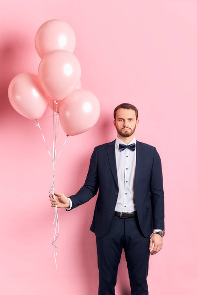 Serious bearded man in tuxedo with air balloons isolated - Фото, изображение