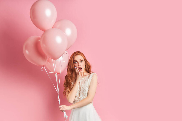 Surprised woman with red hair in dress with air balloons - Foto, Imagem