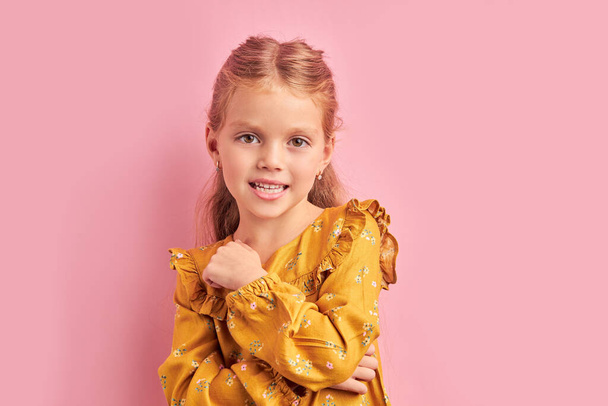 Charming little girl posing isolated over pink background - Фото, зображення