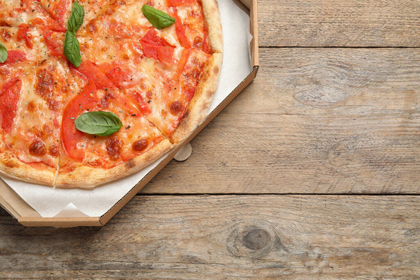 Deliciosa pizza Margherita na mesa de madeira, vista superior. Espaço para texto
 - Foto, Imagem