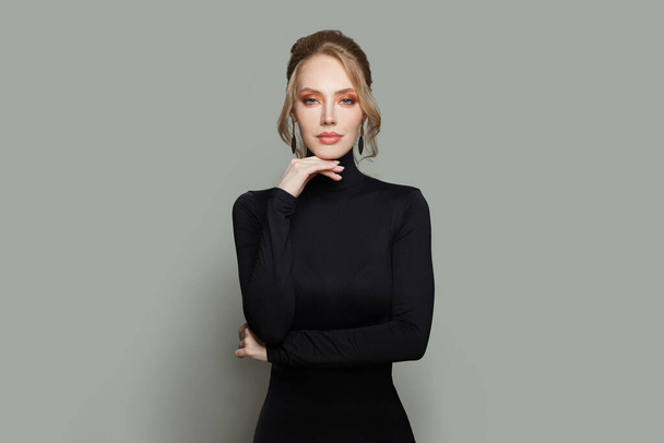 Elegáns modell nő visel fekete garbó pulóver álló szürke fal háttér - Fotó, kép
