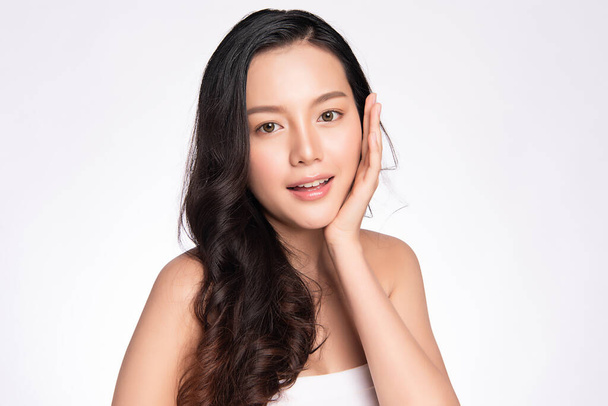 Güzel, genç Asyalı bir kadın temiz yüzüne yeni sağlıklı bir ciltle dokunuyor, beyaz arka planda izole edilmiş, Güzellik Kozmetik ve Yüz Bakımı Konsepti. - Fotoğraf, Görsel