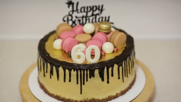 Декорація торта з макаронним печивом, цукерками і білими шоколадними кульками для святкування дня народження матері 60 років. - Кадри, відео
