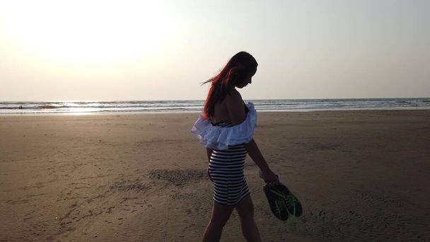 Young slim beautiful woman on sunset beach. - Photo, Image
