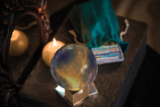 Sihirli kristal küre falcısı, aşk anlatıcısı, gizemli konsept, mumlu mistik sahne, masada tarot kartları. - Fotoğraf, Görsel