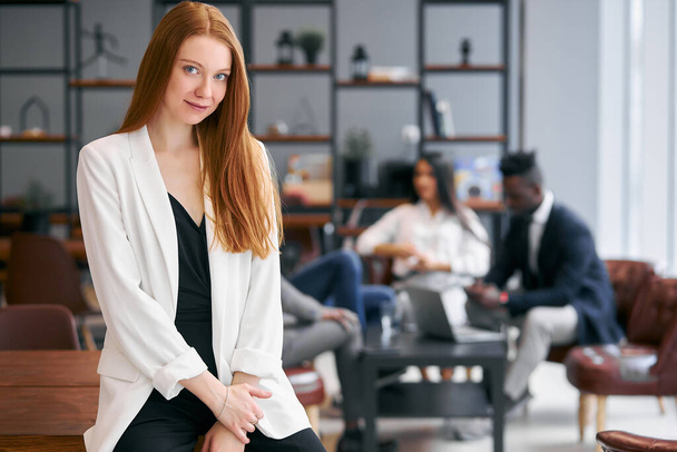 Charming business lady with red hair in office - Photo, Image