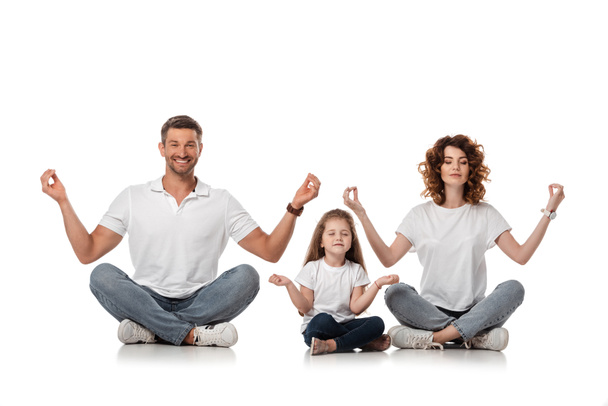 happy family sitting in yoga pose on white  - Фото, изображение