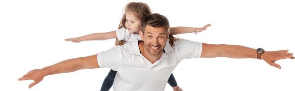 panoramic crop of happy father piggybacking cute daughter with outstretched hands isolated on white  - Photo, Image