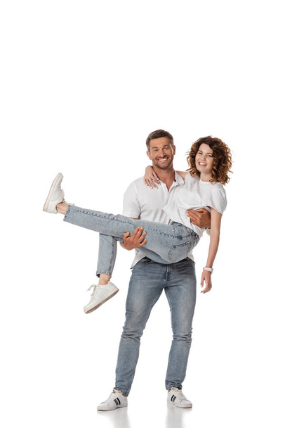 glücklicher Mann mit lockiger Frau auf weißem Arm  - Foto, Bild