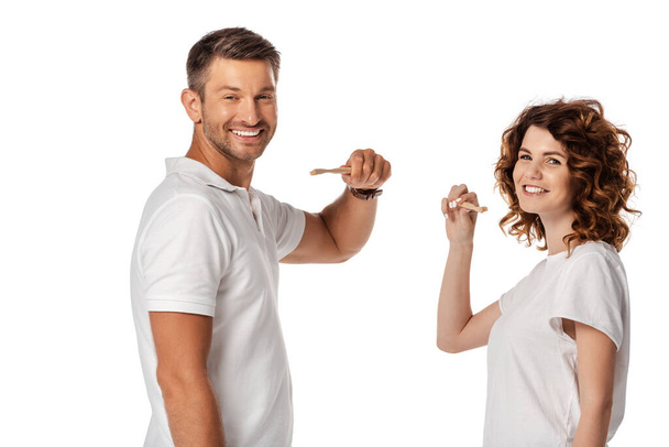 coppia felice tenendo spazzolini isolati su bianco  - Foto, immagini