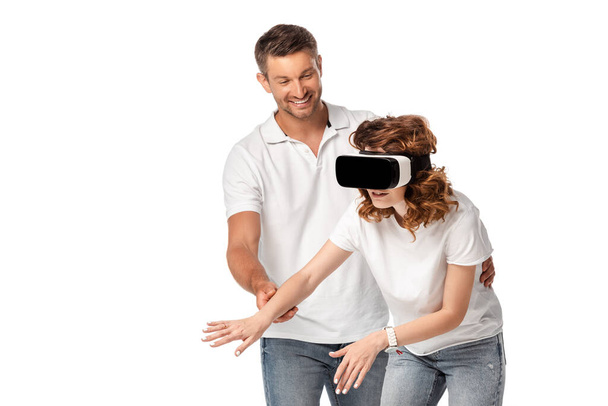 ευτυχισμένος άνθρωπος κοιτάζοντας γυναίκα σε εικονική πραγματικότητα ακουστικά gesturing απομονώνονται σε λευκό  - Φωτογραφία, εικόνα