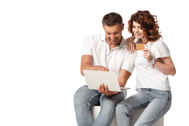 happy woman holding credit card near man using laptop isolated on white - Photo, Image