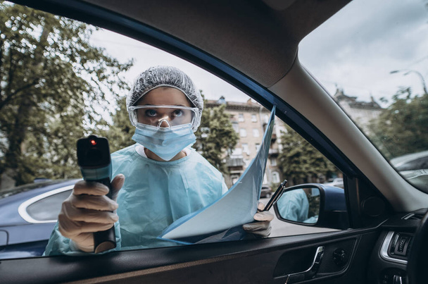 Medico donna uso pistola termometro a infrarossi per controllare la temperatura corporea - Foto, immagini