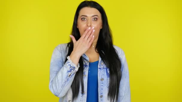 Frau in Jeansjacke hebt Kopf und ist überrascht, Mund mit Handfläche zu bedecken - Filmmaterial, Video