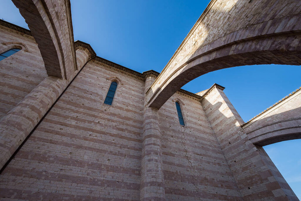 Ассизи, Перуджа, Умбрия. Базилика Санта-Кьяра, важное место поклонения в историческом центре Ассизи, построена в итальянском готическом стиле в 1265 году. - Фото, изображение