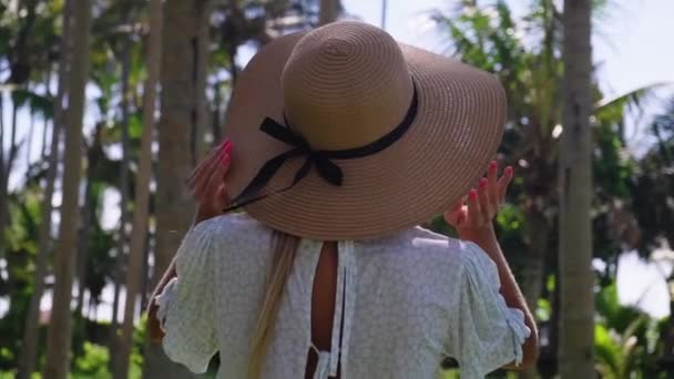 Kobieta w tropikalnym ogrodzie, widok z tyłu - Materiał filmowy, wideo
