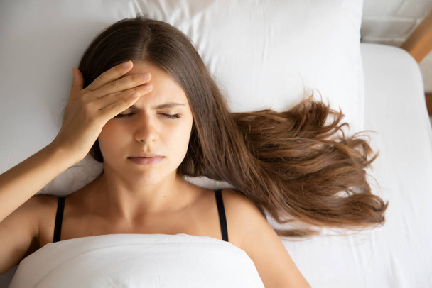 Kranke Frau schläft mit Fieber, Kopfschmerzen oder Alptraum - Foto, Bild