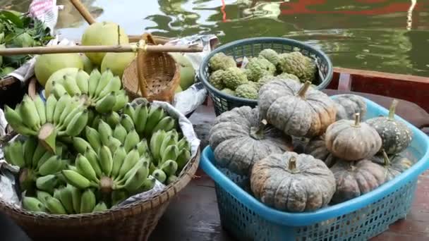 Słynny azjatycki rynek pływający Lat Mayom. Kanał rzeczny Khlong, długa łódź z tropikalnymi egzotycznymi, kolorowymi owocami, organicznymi lokalnie uprawianymi warzywami. Widok góry zbiorów i jedzenie uliczne w drewnianym kajaku - Materiał filmowy, wideo