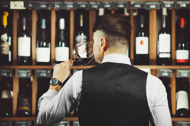 Male sommelier tasting red wine at cellar. - Fotoğraf, Görsel