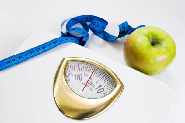 Weegschaal, groene appel, geïsoleerd, wit, afvallen, goede voeding, gezondheid - Foto, afbeelding