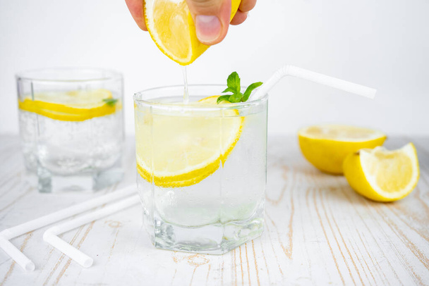 Buzlu ve naneli bir bardak soda ile limon suyu ekleyin. Ferahlatıcı yaz kokteyli konsepti tonik veya şeffaf alkolle - Fotoğraf, Görsel