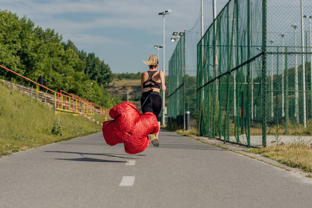 View from the back of a young female athlete running with a parachute in the park - Photo, Image
