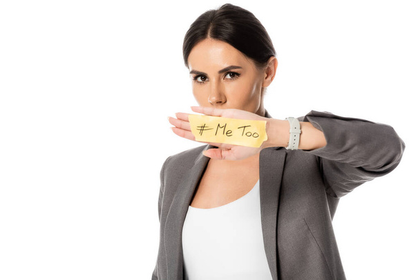 businesswoman with me too lettering on hand covering mouth and looking at camera isolated on white, gender inequality concept  - Photo, Image