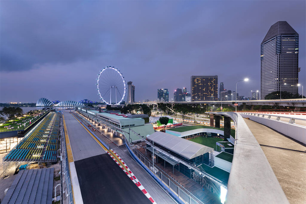 Singapur - 9 Wrz 2019: tor Marina Bay Street zaprasza na nocny wyścig Formuły 1 Grand Prix Singapuru, mijający koło diabelskiego młyna Flyer, ogrody nad zatoką i kurorty Sands - Zdjęcie, obraz