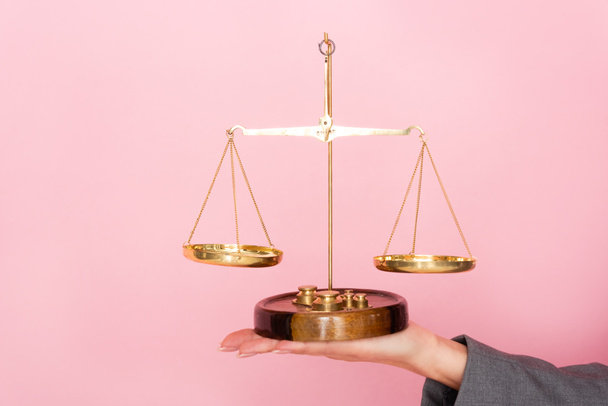 bijgesneden beeld van zakenvrouw met gouden schalen geïsoleerd op roze, gendergelijkheid concept  - Foto, afbeelding