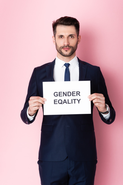 businessman holding placard with gender equality lettering on pink  - Zdjęcie, obraz