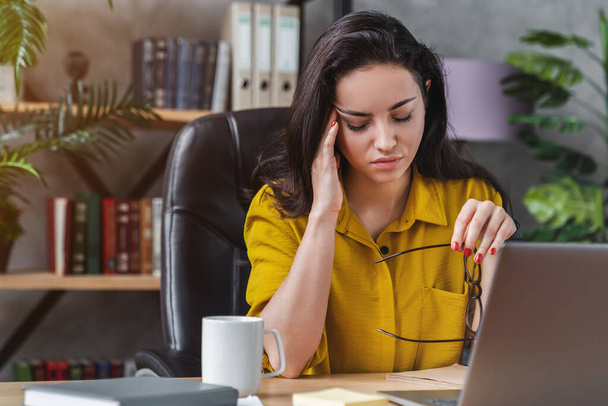 Freelance working woman with laptop computer has headache and stress on job - Фото, изображение