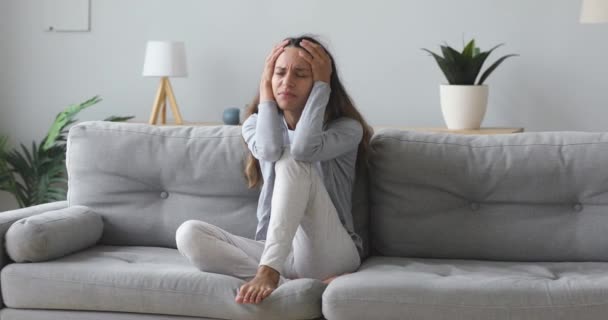 Stressed worried young woman desperate about problem sit on sofa - Filmmaterial, Video